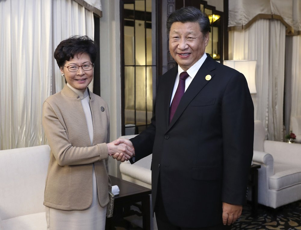 In this Nov. 4, 2019, file photo released by China's Xinhua News Agency, Chinese President Xi Jinping, right, poses with Hong Kong Chief Executive Carrie Lam for a photo during a meeting in S