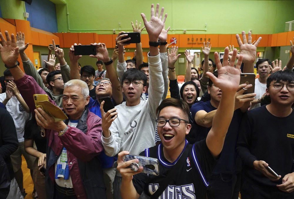 Supporters of pro-democracy candidate Angus Wong celebrate after he won in district council elections in Hong Kong, early Monday, Nov. 25, 2019.