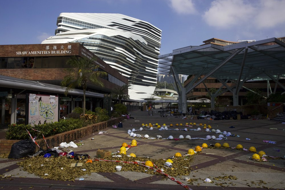 Hard hats and pieces of cloth linked to form the words SOS, placed by protesters, are seen on the Hong Kong Polytechnic University campus in Hong Kong, Wednesday, Nov. 27, 2019.