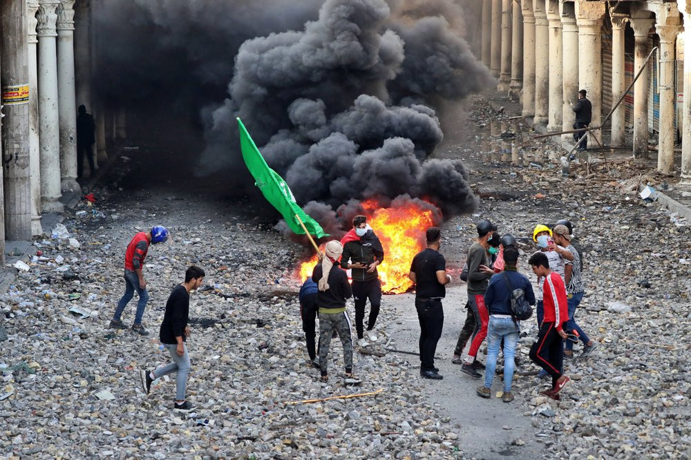 Anti-government protesters set fire while security forces close Rasheed Street during clashes in Baghdad, Iraq, Thursday, Nov. 28, 2019.