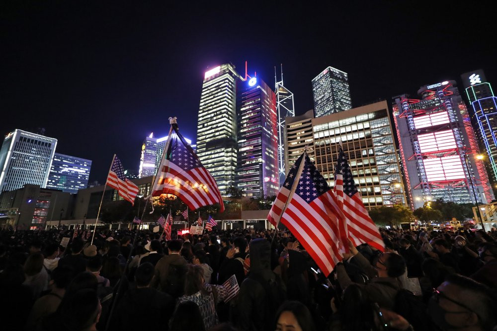 Protester holds U.S. flags during a demonstration in Hong Kong, Thursday, Nov. 28, 2019.