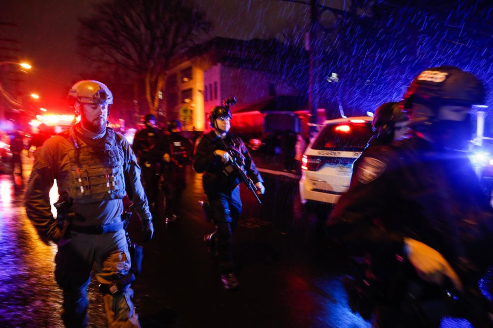 Law enforcement personnel walk near the scene following a shooting, Tuesday, Dec. 10, 2019, in Jersey City, N.J.