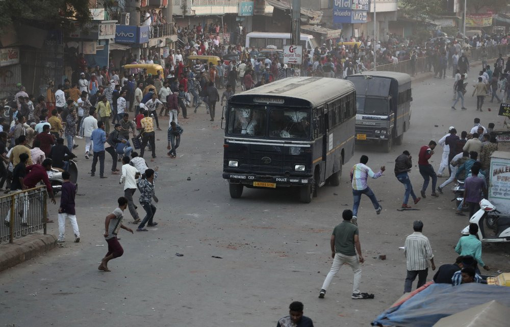 Indians throw stones on police vehicles during a protest against the Citizenship Amendment Act and the National Register of Citizens in Ahmadabad, India, Thursday.