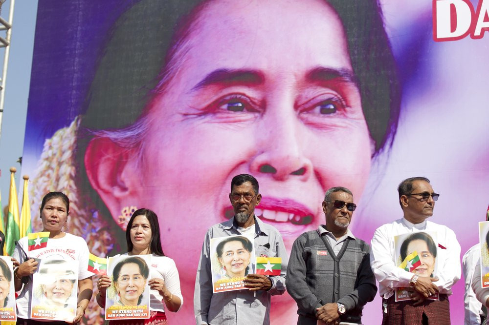 In this Tuesday, Dec. 10, 2019 file photo, Members of Myanmar Muslims community hold portraits of Myanmar leader Aung San Suu Kyi to pray as they gather in front of City Hall in Yangon, Myanm