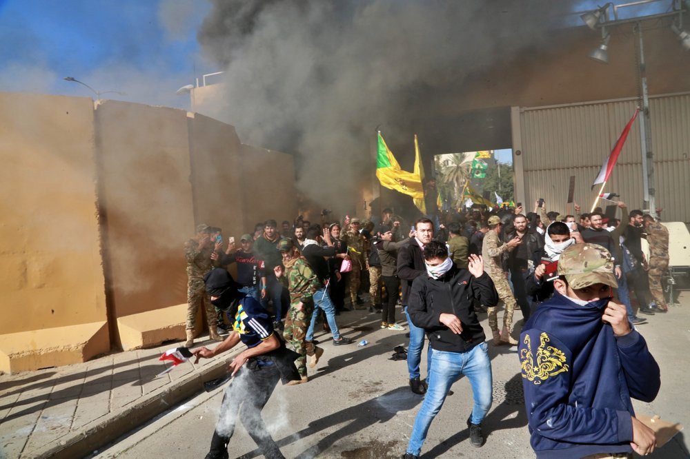 US soldiers fire tear gas towards protesters who broke into the U.S. embassy compound, in Baghdad, Iraq, Tuesday, Dec. 31, 2019.
