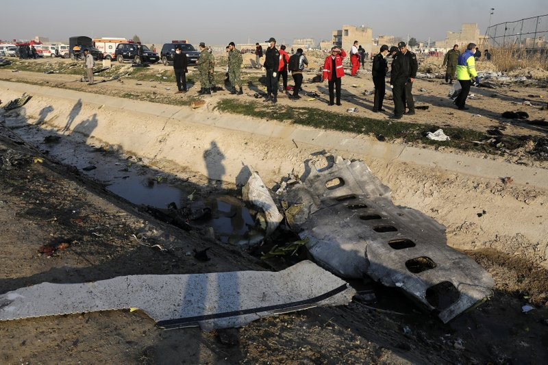 In this Jan. 8, 2020, photo, debris is seen from an Ukrainian plane which crashed as authorities work at the scene in Shahedshahr, southwest of the capital Tehran, Iran.