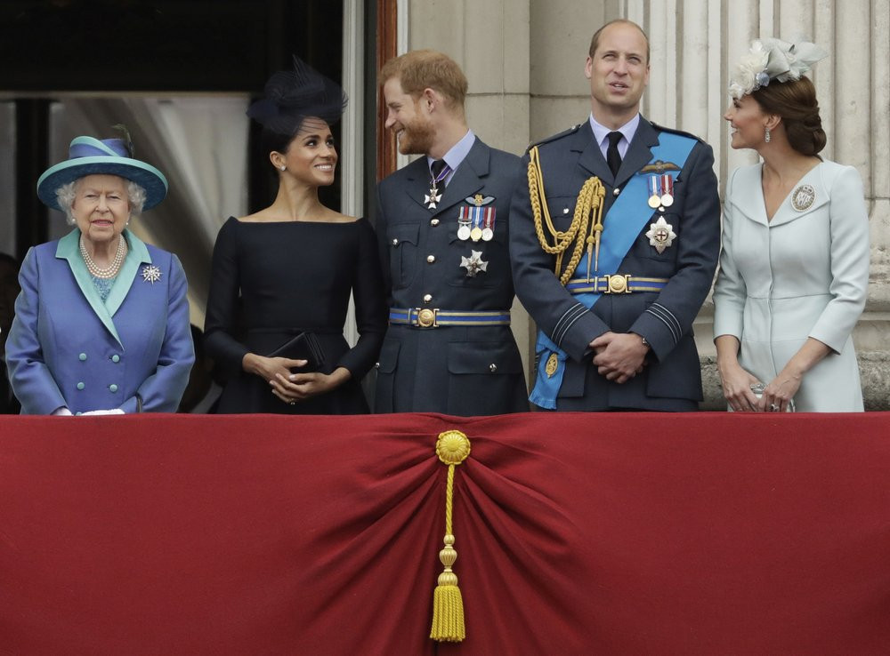File photo of Britain's Queen Elizabeth II, and from left, Meghan the Duchess of Sussex, Prince Harry, Prince William and Kate the Duchess of Cambridge