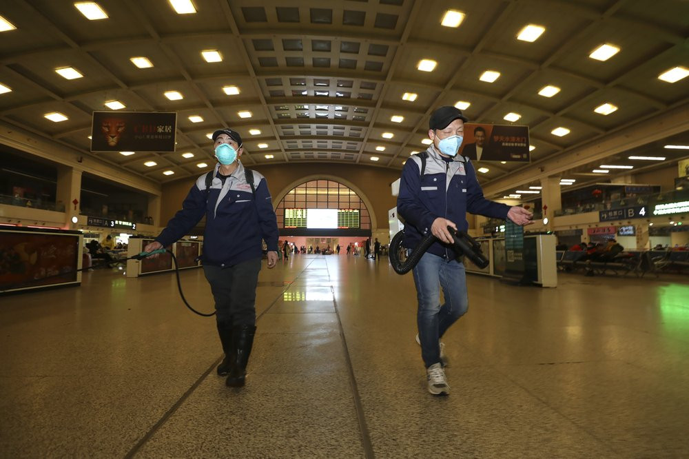 Workers spray disinfectant at a train station in Wuhan in southern China's Hubei province, Wednesday, Jan. 22, 2020.