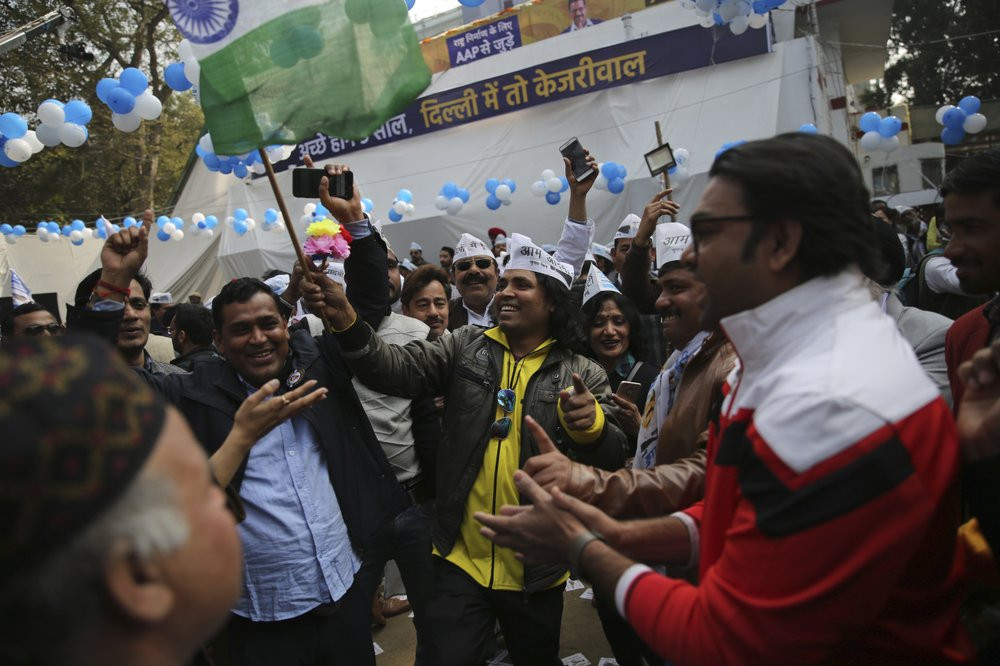 Supporters of the Aam Aadmi Party, or "common man's" party, celebrate as initial results show the party in the lead, at their party office in New Delhi, India, Tuesday, Feb. 11, 2020.