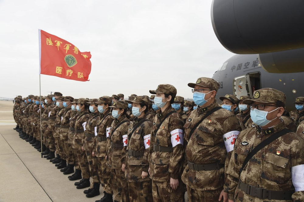 In this photo released by China's Xinhua News Agency, Chinese military medics arrive at the Tianhe International Airport in Wuhan, central China's Hubei Province, Feb. 13, 2020.
