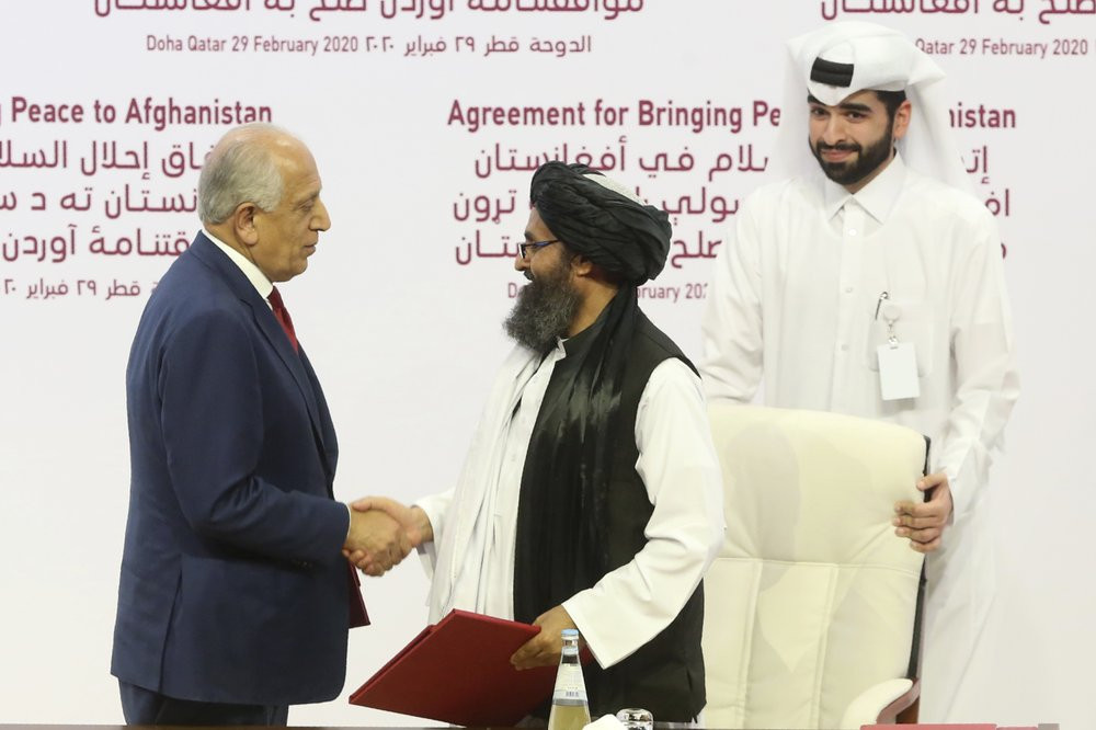 U.S. peace envoy Zalmay Khalilzad, left, and Mullah Abdul Ghani Baradar, the Taliban group's top political leader shack hands after signing a peace agreement between Taliban and U.S. official