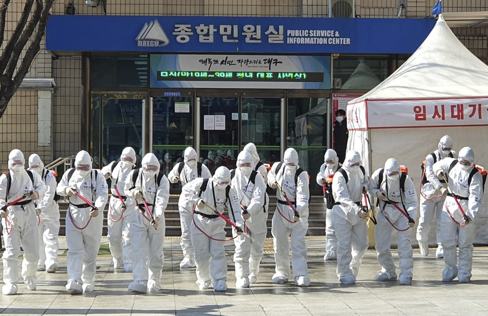 South Korean soldiers wearing protective suits spray disinfectant to prevent the spread of a new coronavirus in front of the Daegu city hall in Daegu, South Korea, Monday, March 2, 2020.