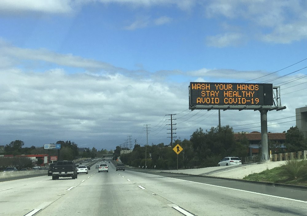 A Caltrans freeway sign reads: "Wash your hands, Stay healthy, Avoid COVID-19" in the San Fernando Valley section of Los Angeles.