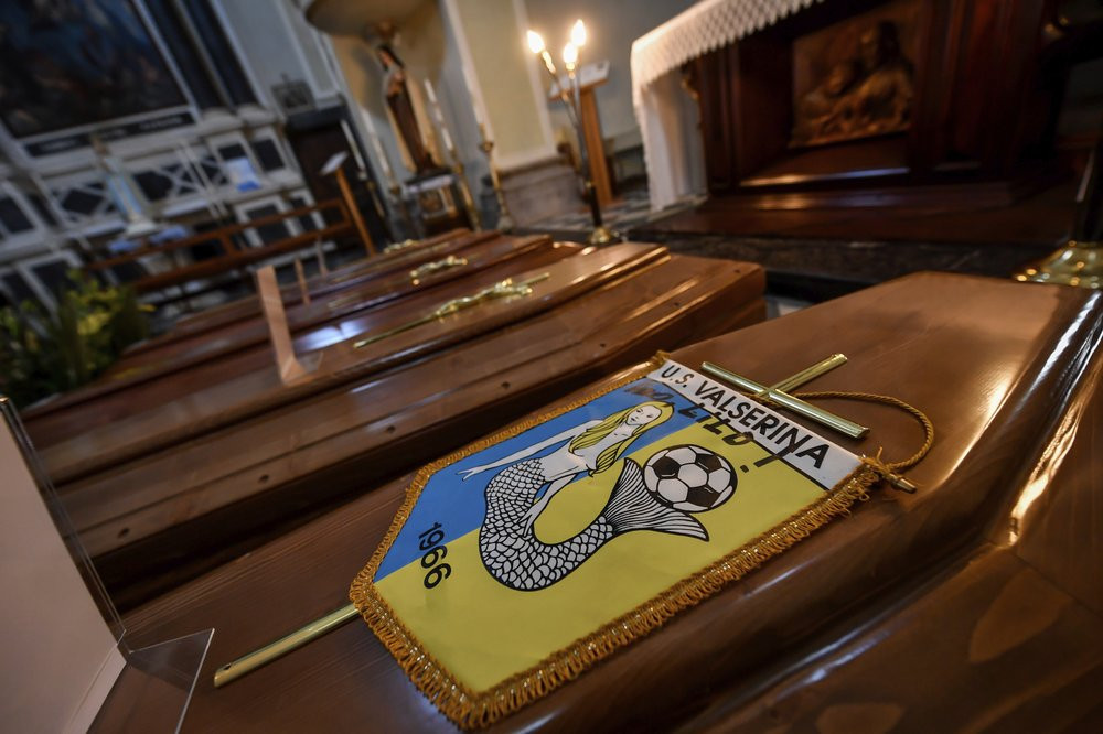 Coffins, one of them with the pennant of the local soccer team, wait to be transported to cemetery, in the church of Serina, near Bergamo, Northern Italy, Saturday, March 21, 2020.