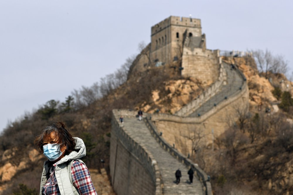 A woman wearing a protective face mask visits the Badaling Great Wall of China after it reopened for business following the new coronavirus outbreak in Beijing, China, Tuesday, March 24, 2020