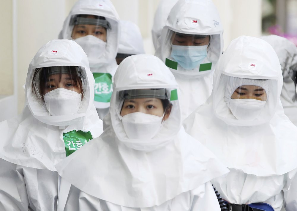 Medical staff members arrive for a duty shift at Dongsan Medical Center in Daegu, South Korea, Monday, March 30, 2020.