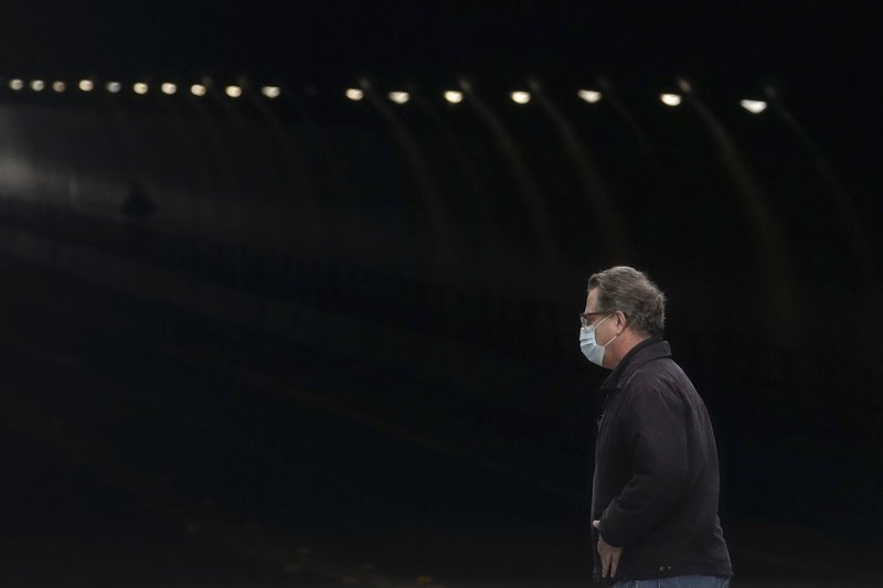 A man wears a mask while crossing in front of the Stockton Street Tunnel in San Francisco, Sunday, March 29, 2020.