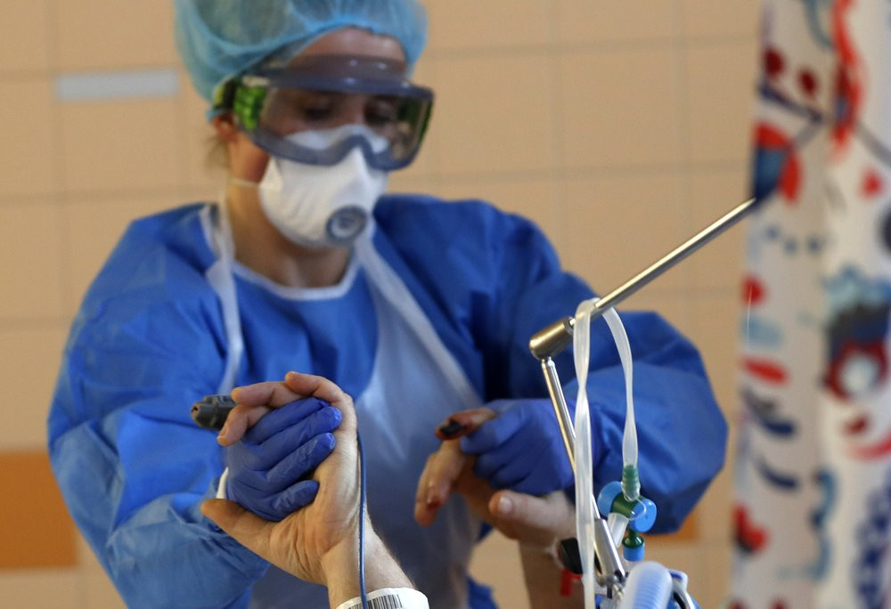 A healthcare worker attends to a COVID-19 patient in an intensive care unit (ICU) at the General University Hospital in Prague, Czech Republic, Tuesday, April 7, 2020.