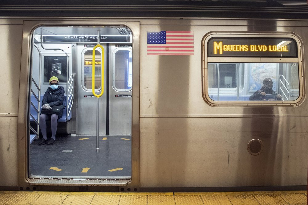 Commuters wear face masks for protection against the coronavirus as they ride the M train, Friday, April 10, 2020, in New York.