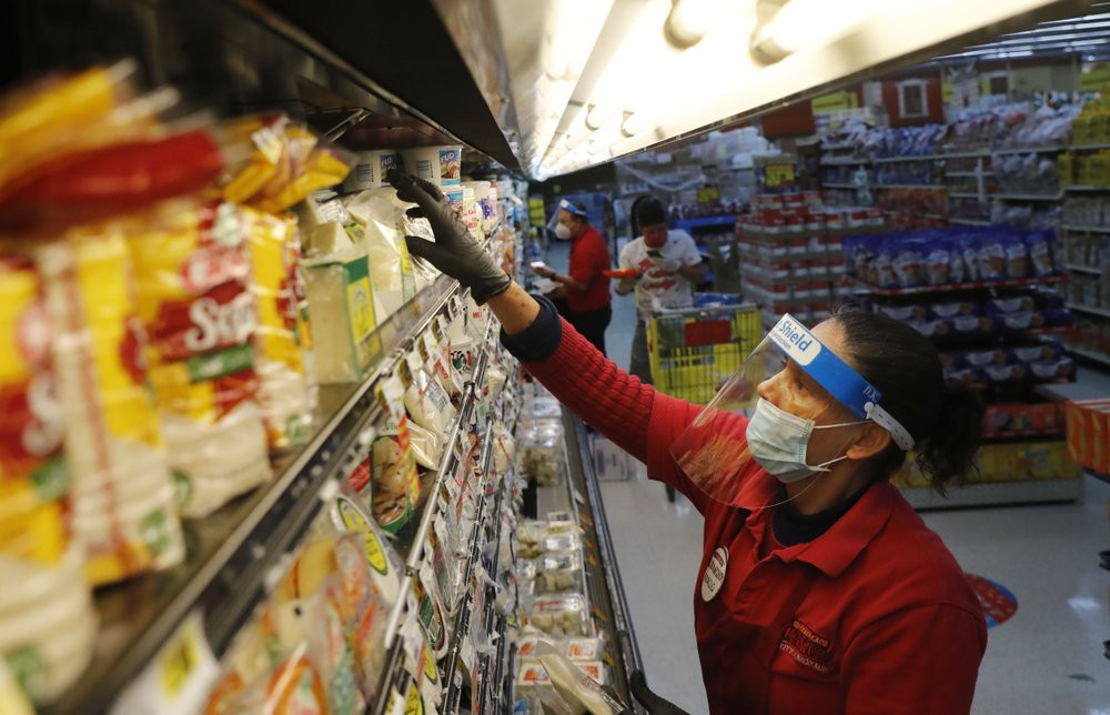 Amid concerns of the spread of COVID-19, Maclola Orozco restocks food at El Rancho grocery store in Dallas, Monday, April 13, 2020.