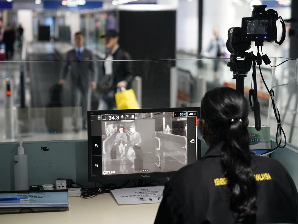 Health officials watch thermographic monitors at a quarantine inspection station at the Kuala Lumpur International Airport in Sepang, Malaysia, Tuesday, Jan. 21, 2020.
