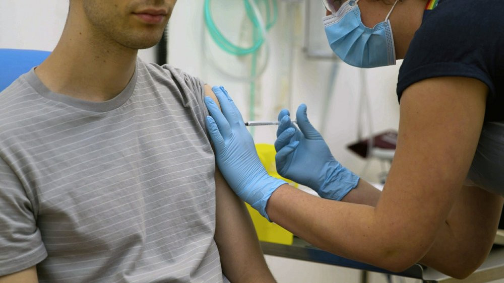 In this screen grab from video issued by Britain's Oxford University, a volunteer is injected with either an experimental COVID-19 vaccine or a comparison shot as part of the first human tria