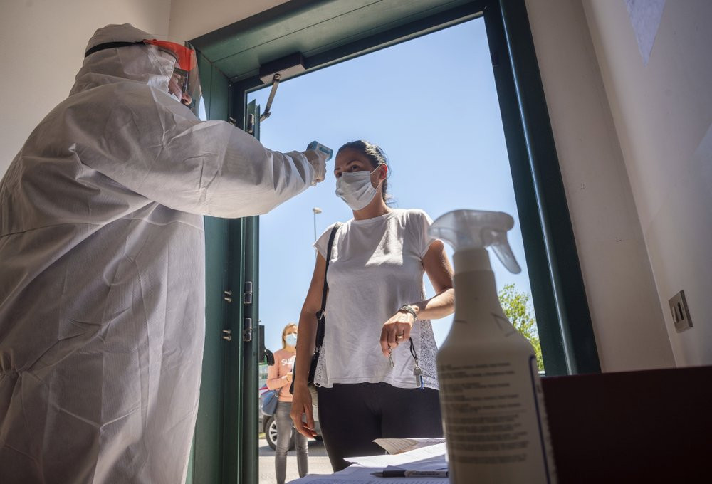 A worker of the Calzaturificio M.G.T shoe factory in Castelnuovo Vomano, central Italy, has her temperature checked at the entrance of the factory when she returns to work, Monday, May 4, 202