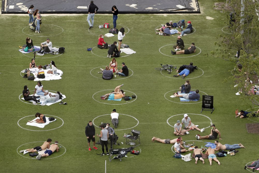 People relax in marked circles for proper social distancing at Domino Park in the Williamsburg neighborhood of Brooklyn during the current coronavirus outbreak, Sunday, May 17, 2020, in New Y