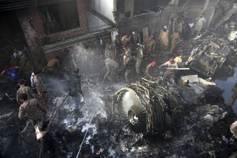 Volunteers look for survivors of a plane that crashed in residential area of Karachi, Pakistan, May 22, 2020.