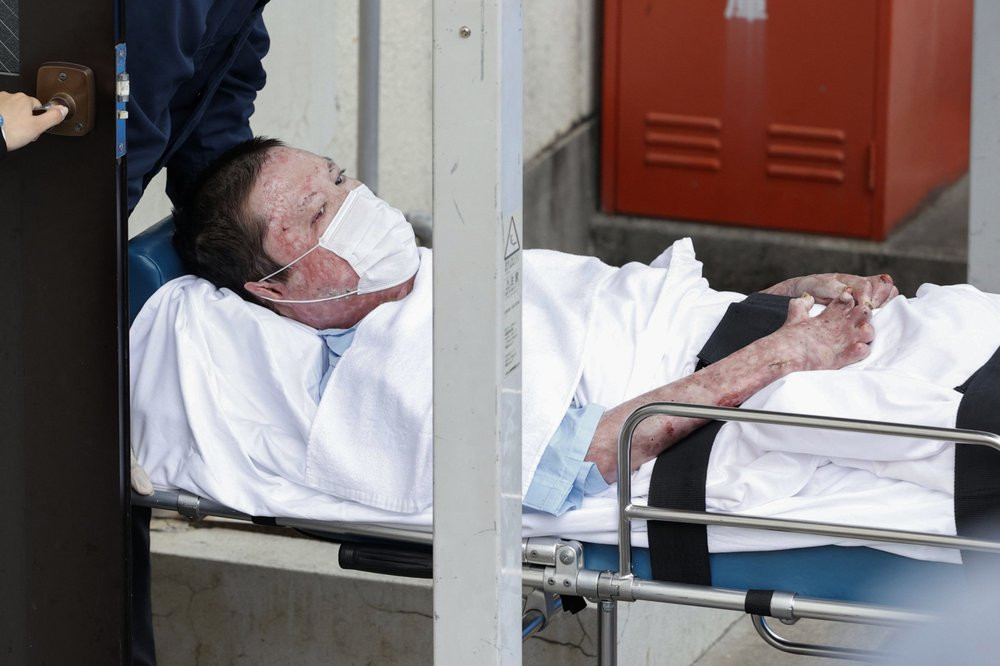 Shinji Aoba on a stretcher is carried to Fushimi police station after being arrested in Kyoto, western Japan, Wednesday, May 27, 2020.