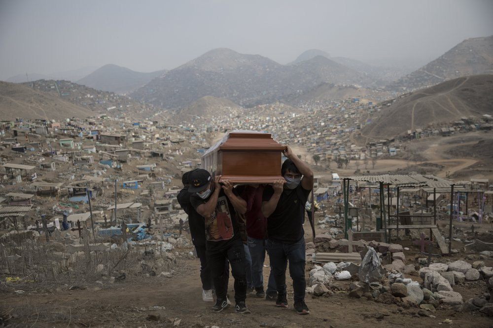 Relatives carry the coffin of a suspected COVID-19 victim at the Nueva Esperanza cemetery on the outskirts of Lima, Peru, Thursday, May 28, 2020.