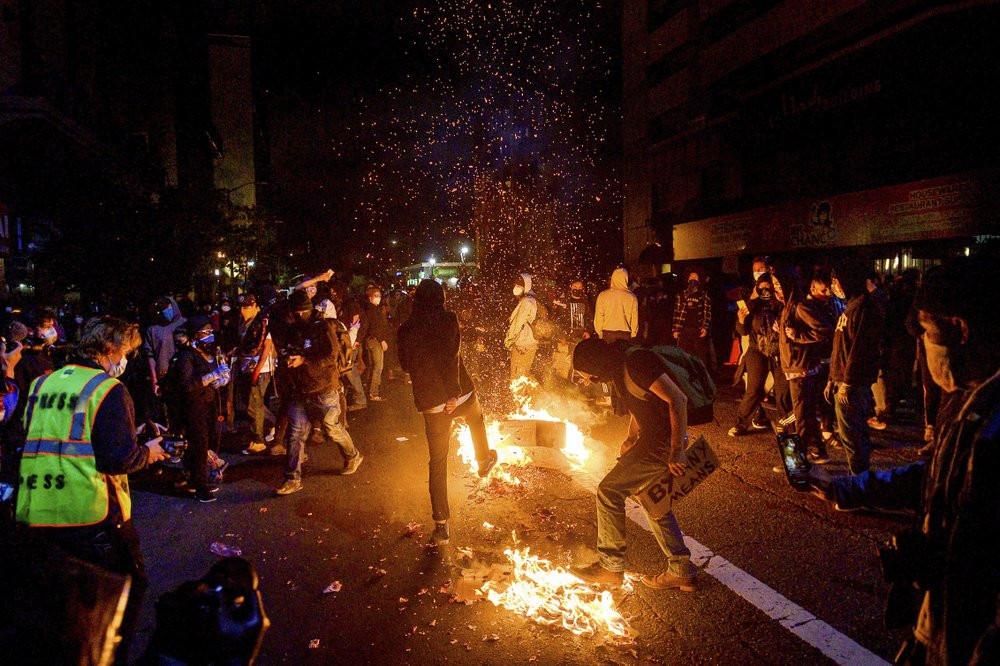 Demonstrators burn garbage in Oakland, Calif., on Friday, May 29, 2020, while protesting the Monday death of George Floyd, a handcuffed black man in police custody in Minneapolis.