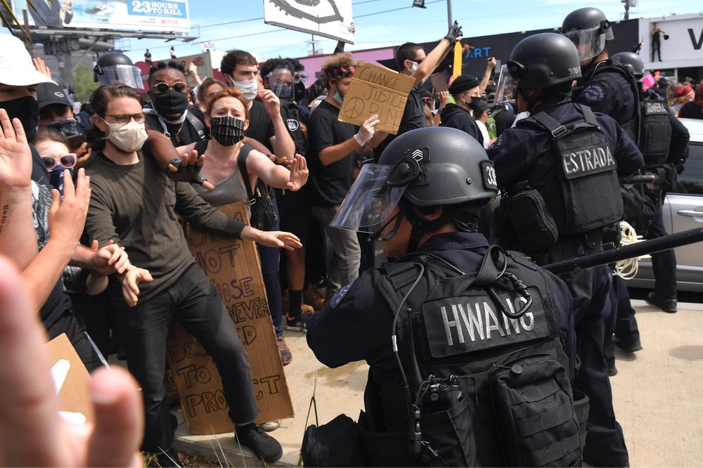 A Los Angeles police officer threatens protesters during a protest over the death of George Floyd Saturday, May 30, 2020, in Los Angeles.