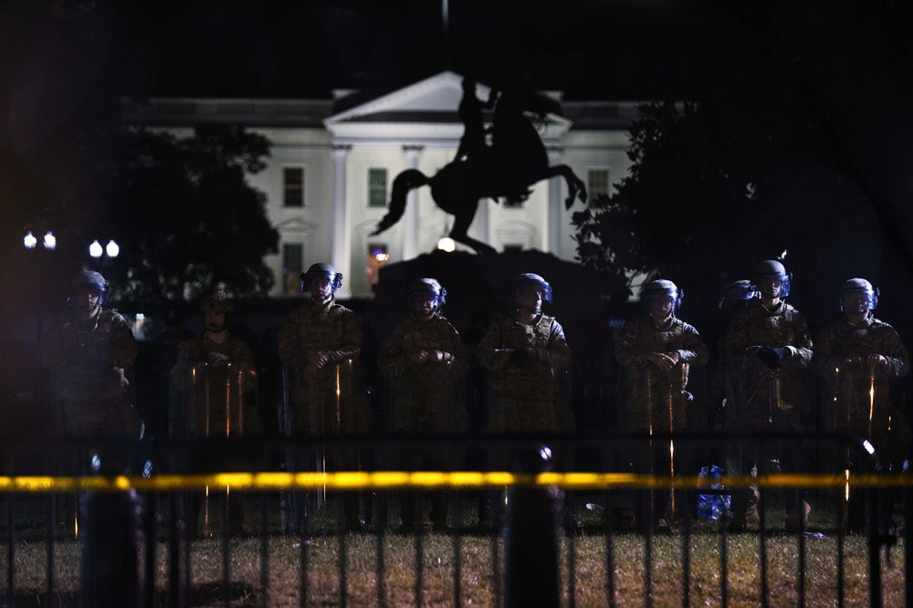 With the White House in the background, a line of police forms behind a fence in Lafayette Park as demonstrators gather to protest the death of George Floyd, Tuesday, June 2, 2020, in Washing