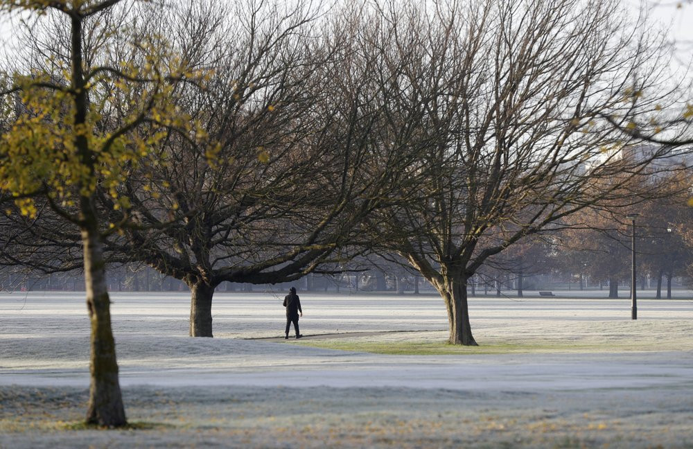 A man walks across the frost covered fairways of a golf course in central Christchurch, New Zealand, Saturday.