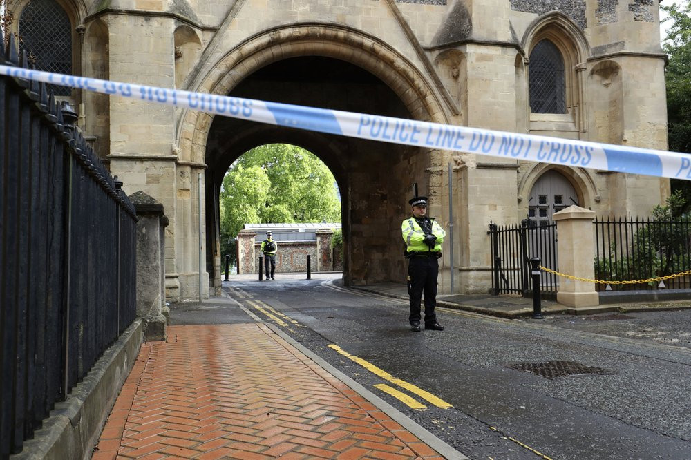 Police stand guard at the Abbey gateway of Forbury Gardens park in Reading town centre following Saturday's stabbing attack in the gardens, Sunday June 21, 2020.