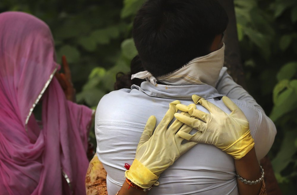 A couple whose relative died of COVID-19 mourns and consoles each other during the cremation in New Delhi, India, Wednesday, July 1, 2020.