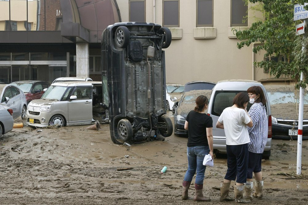 A car stands vertically on a muddy road after being washed away by flood, in Hitoyoshi, Kumamoto prefecture, southwestern Japan, Sunday, July 5, 2020.