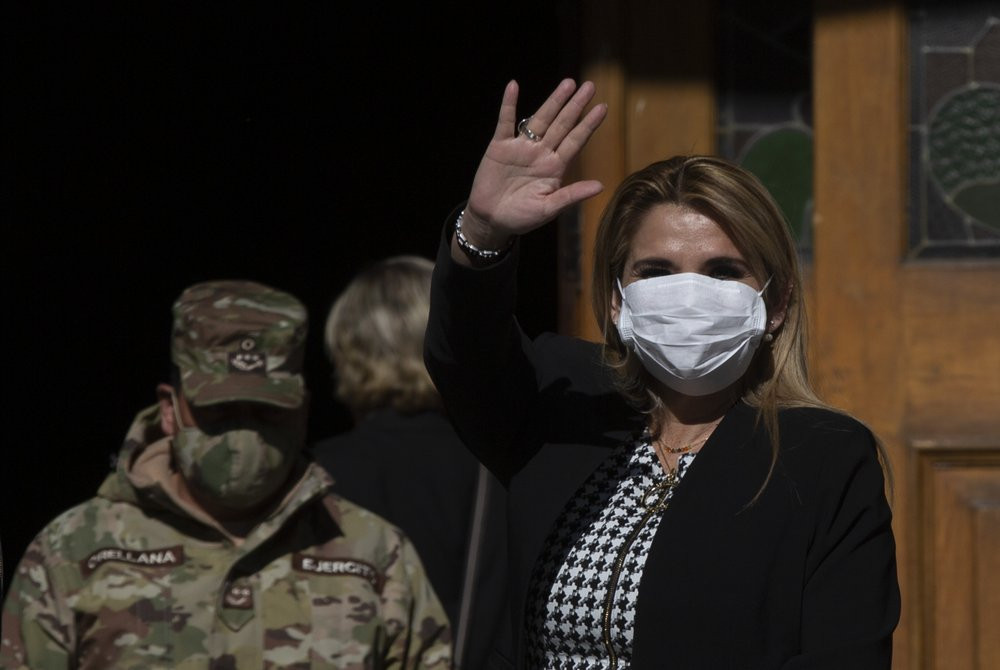 Bolivia's interim President Jeanine Anez, wearing a face mask to help curb the spread of the new coronavirus, waves during a procession Corpus Christi, in La Paz, Bolivia, Thursday, June 11, 