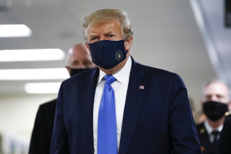 US President Donald Trump wears a mask as he walks down the hallway during his visit to Walter Reed National Military Medical Center in Bethesda, Md., Saturday, July 11, 2020.