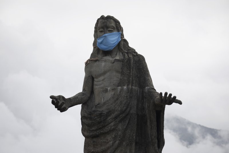 A protective face mask adorns a Jesus Christ statue as a reminder for residents to wear masks as a precaution against the spread of the new coronavirus, in the Petare neighborhod in Caracas, 