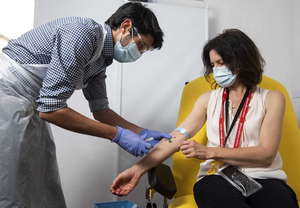 In this handout photo released by the University of Oxford a doctor takes blood samples for use in a coronavirus vaccine trial in Oxford, England, Thursday June 25, 2020.
