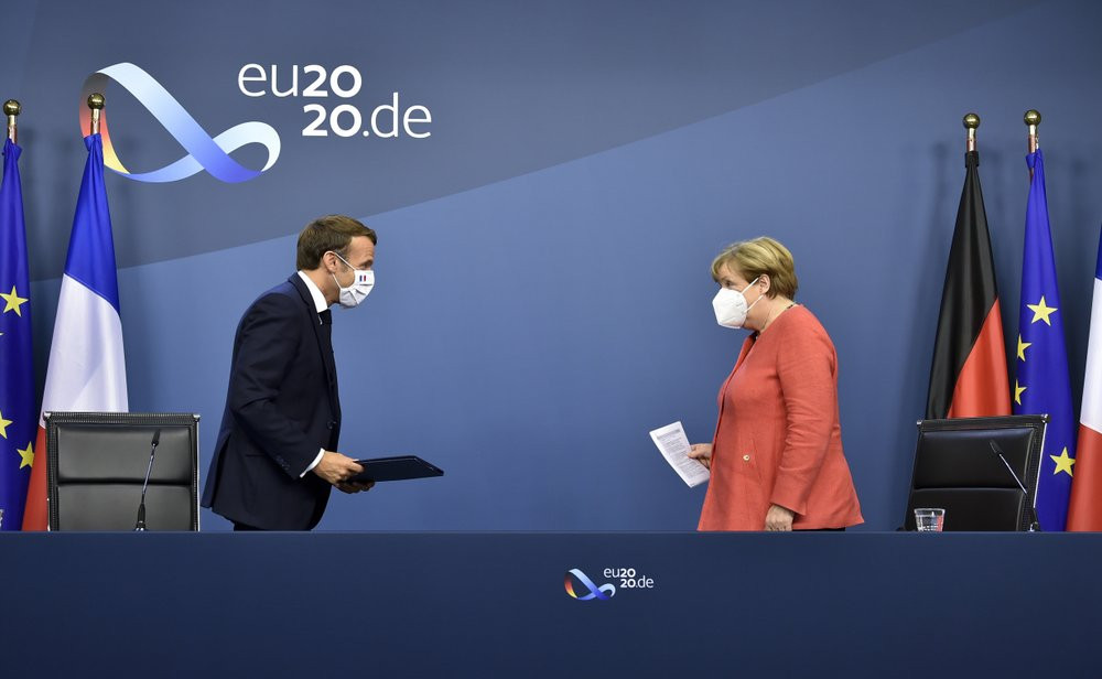 German Chancellor Angela Merkel, right, and French President Emmanuel Macron prepare to address a media conference at the end of an EU summit in Brussels, Tuesday, July 21, 2020.