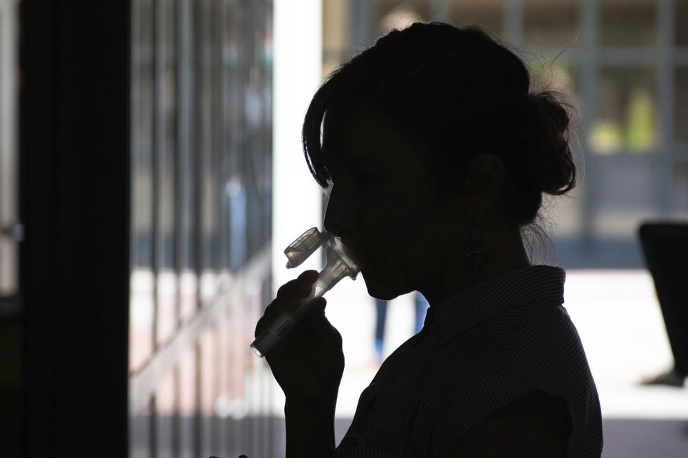 In this June 23, 2020 photo provided by UC Berkeley, a student provides saliva for an experimental COVID-19 coronavirus test for asymptomatic people.
