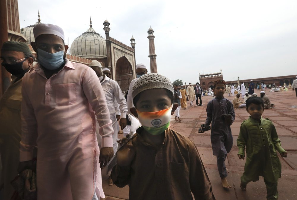 An Indian Muslim boy wears a protective mask in the colors of the Indian national flag, leaves after offering Eid al-Adha prayer at the Jama Masjid in New Delhi, India, Saturday, Aug.1, 2020.