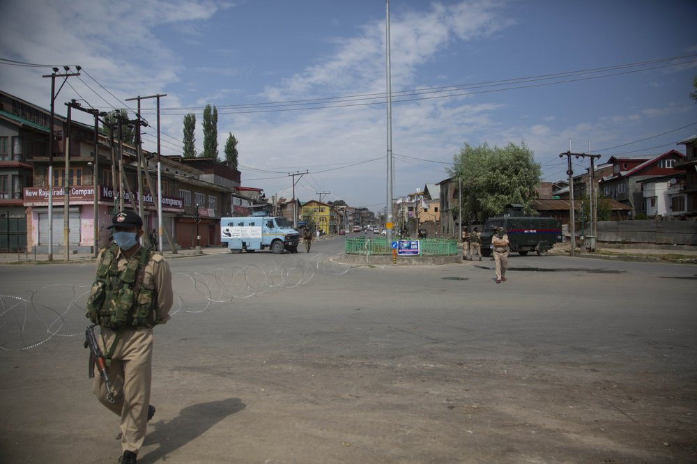 Policemen and paramilitary soldiers patrol a road during curfew in Srinagar, Indian controlled Kashmir, Tuesday, Aug. 4, 2020.