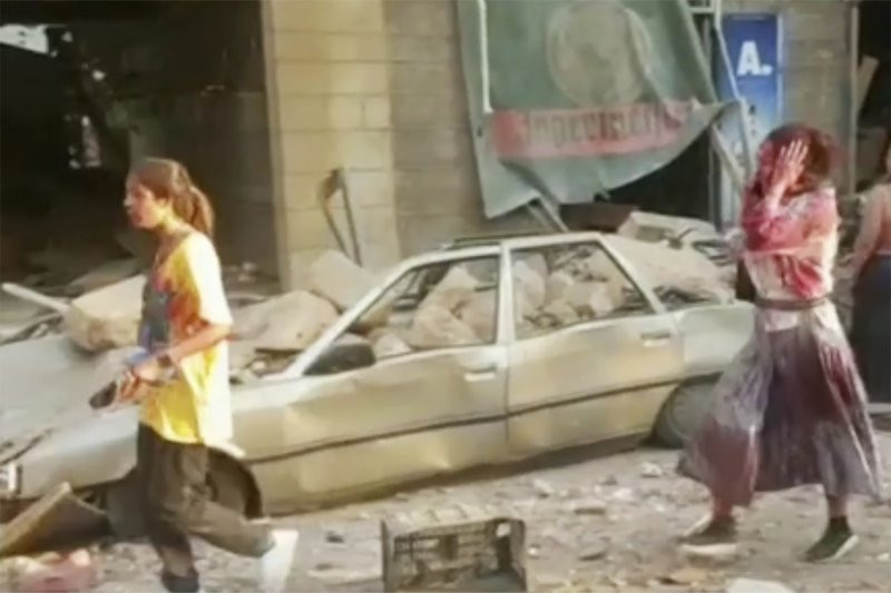 In this frame from video people walk down the street after an explosion in Beirut, Tuesday, Aug. 4, 2020. A massive explosion shook Lebanon's capital wounding a number people and causing wide