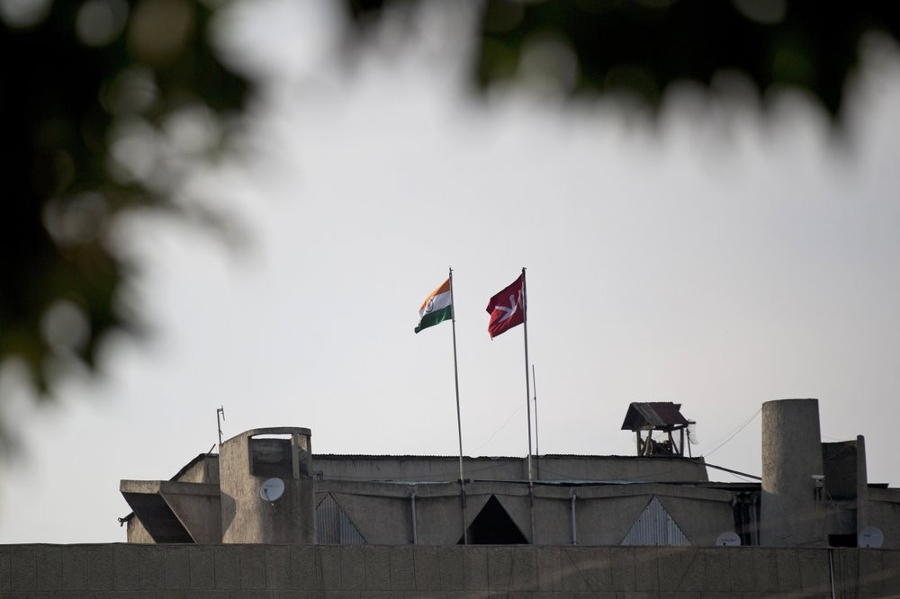 In this Aug. 9, 2019, file photo, an Indian national flag, left, is hoisted next to a Jammu and Kashmir state flag on the government secretariat building after New Delhi scrapped the disputed