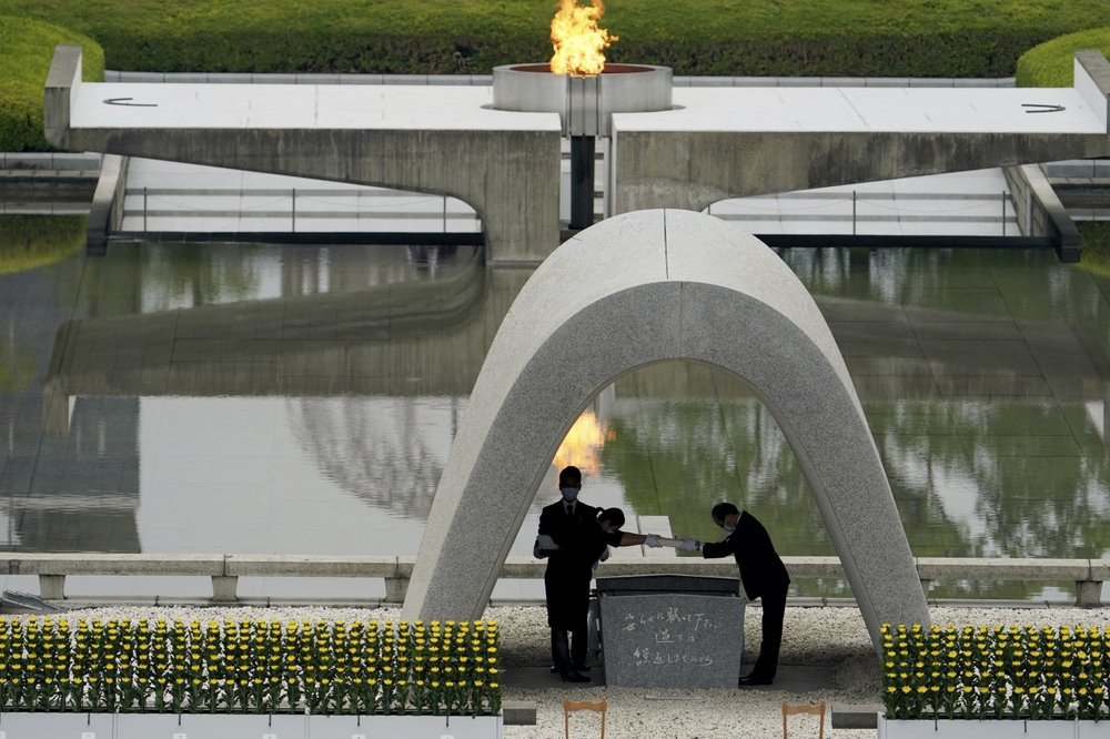 Kazumi Matsui, right, mayor of Hiroshima, and the family of the deceased bow before they place the victims list of the Atomic Bomb at Hiroshima Memorial Cenotaph.
