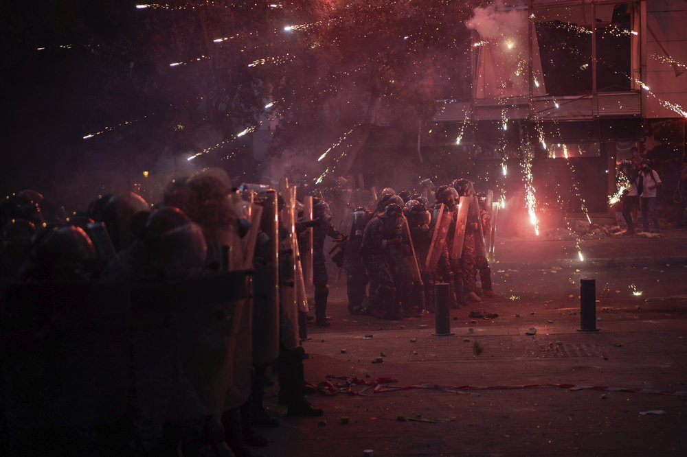 Fireworks thrown by anti-government protesters explode over Riot Police during clashes near the parliament building following last Tuesday's massive explosion in the seaport which devastated 